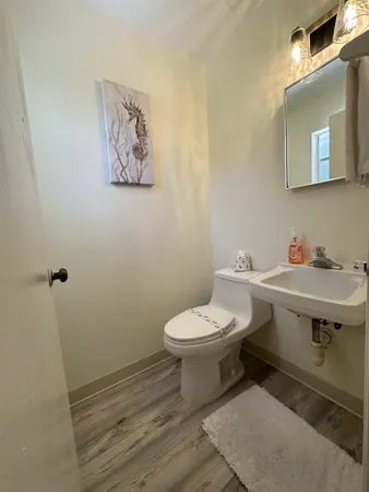 a bathroom with a toilet a sink and mirror