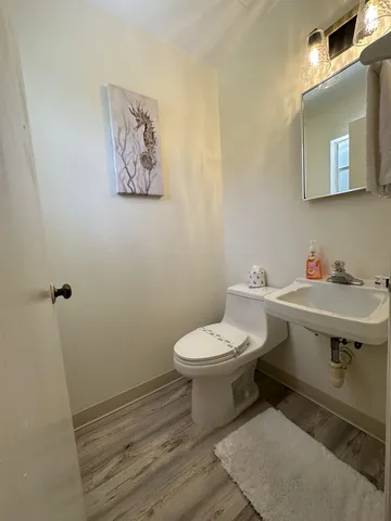 a bathroom with a toilet a sink and mirror
