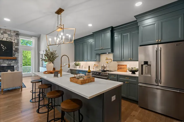 a kitchen with a dining table chairs refrigerator and microwave