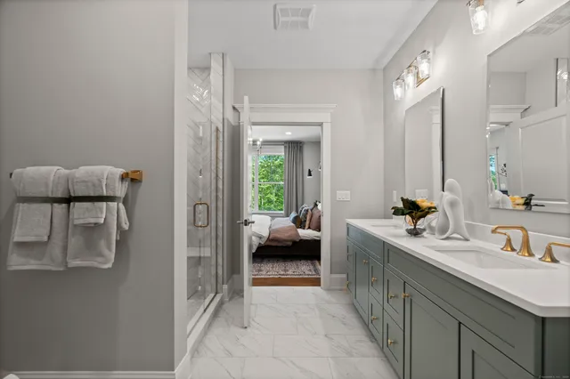 a en suite bathroom with a double vanity sink a mirror and a shower