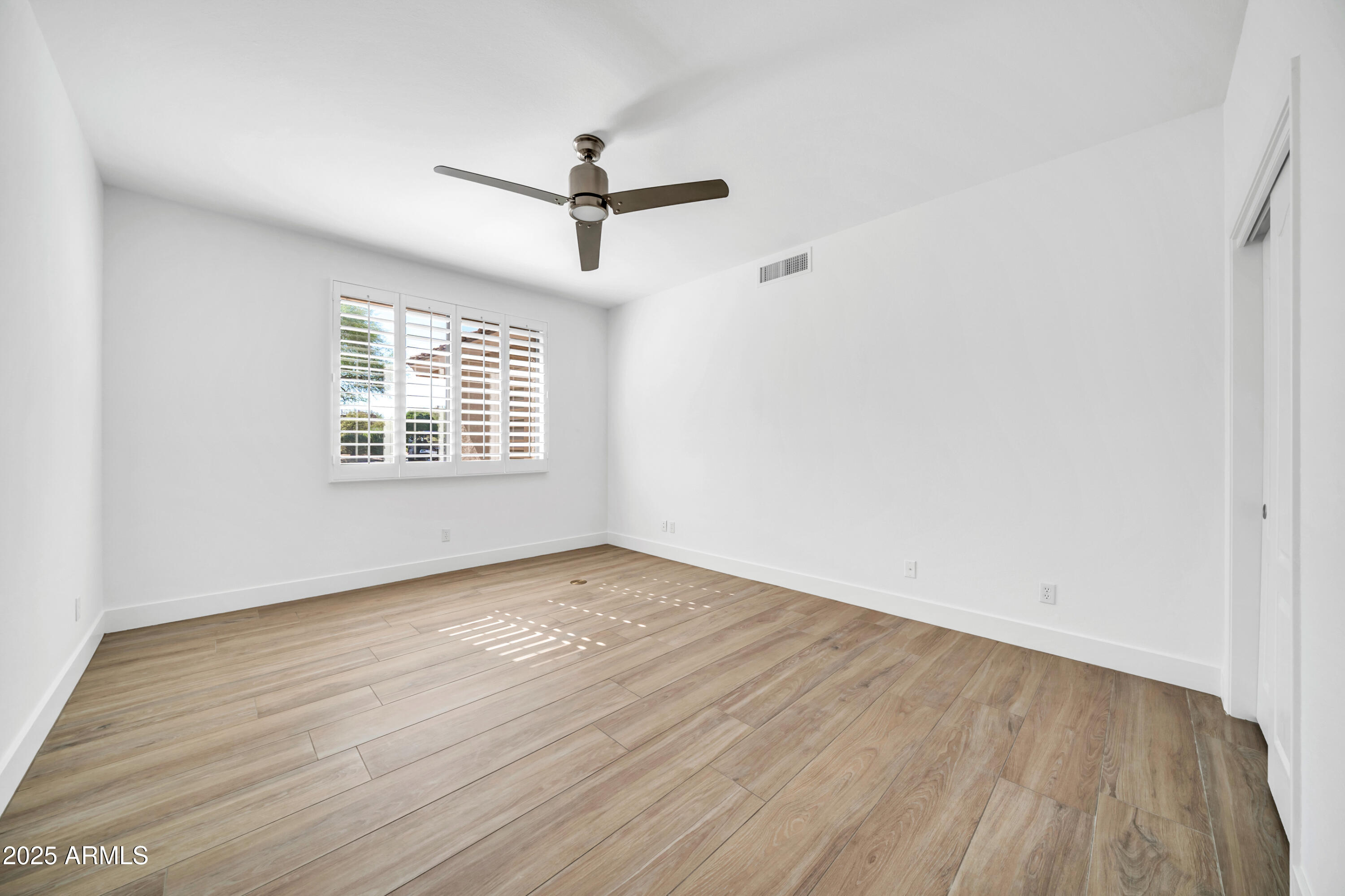 18820 East Gemmill Drive Rio Verde, AZ 85263 - Photo 45 of 72 an empty room with wooden floor fan and windows