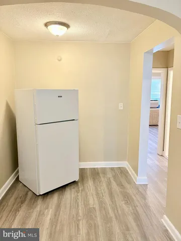 a view of a room with wooden floor and a hallway