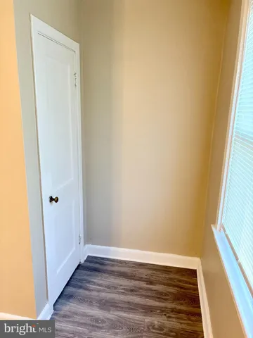 a view of a small space with wooden floor and a window