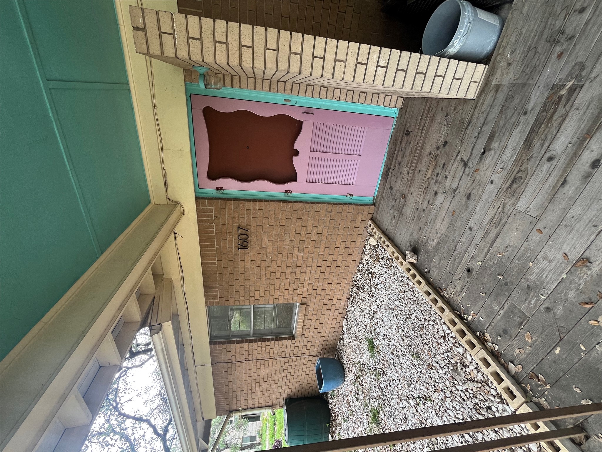 1607 Lightsey Road, Unit A Austin, TX 78704 - Photo 3 of 17 Brick facade with a vibrant pink entry door and teal trim
