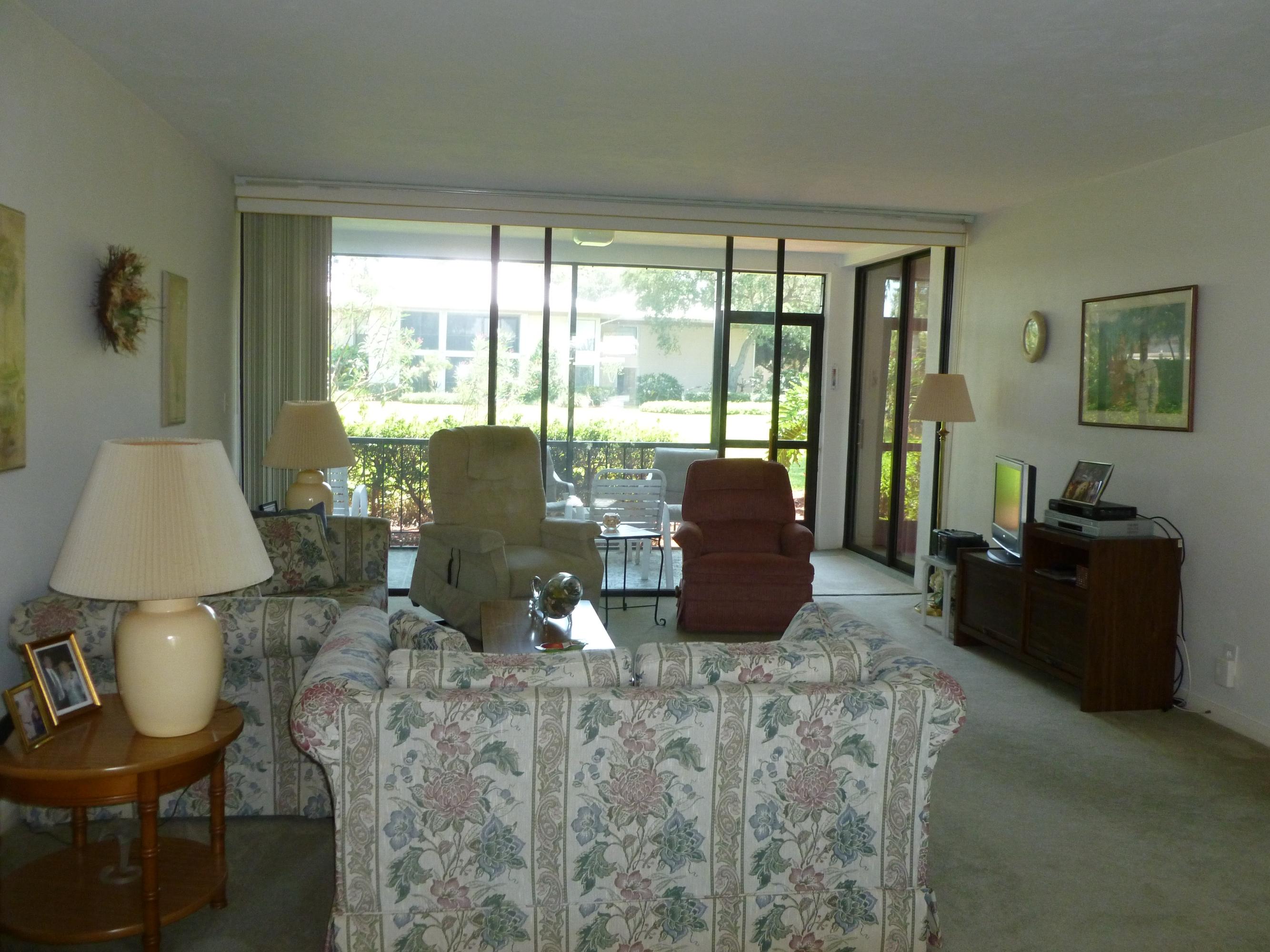 6 Concourse Drive, Unit 6B Jupiter, FL 33469 - Photo 3 of 28 LIVING ROOM TO SCREENED PATIO