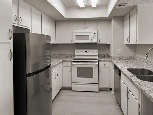 a kitchen with white cabinets and white appliances