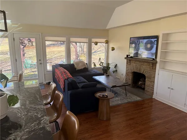 a living room with furniture a fireplace and a floor to ceiling window
