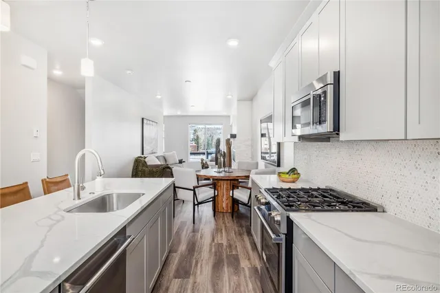 a kitchen with stainless steel appliances granite countertop a sink stove and refrigerator