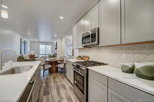 a kitchen with stainless steel appliances granite countertop a sink stove and microwave