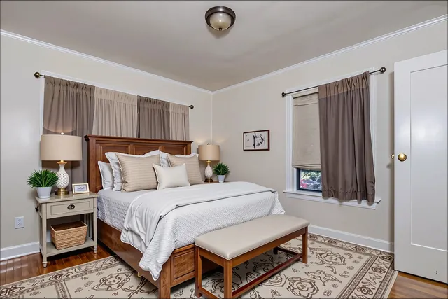 a bedroom with a bed a dresser and a window