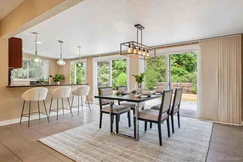 a dining room with furniture a chandelier and wooden floor