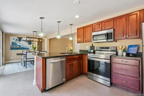 a kitchen with stainless steel appliances granite countertop a stove a sink and a refrigerator