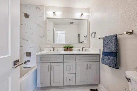 a spacious bathroom with a double vanity sink mirror and toilet