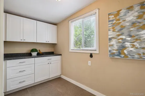a kitchen with granite countertop white cabinets and sink