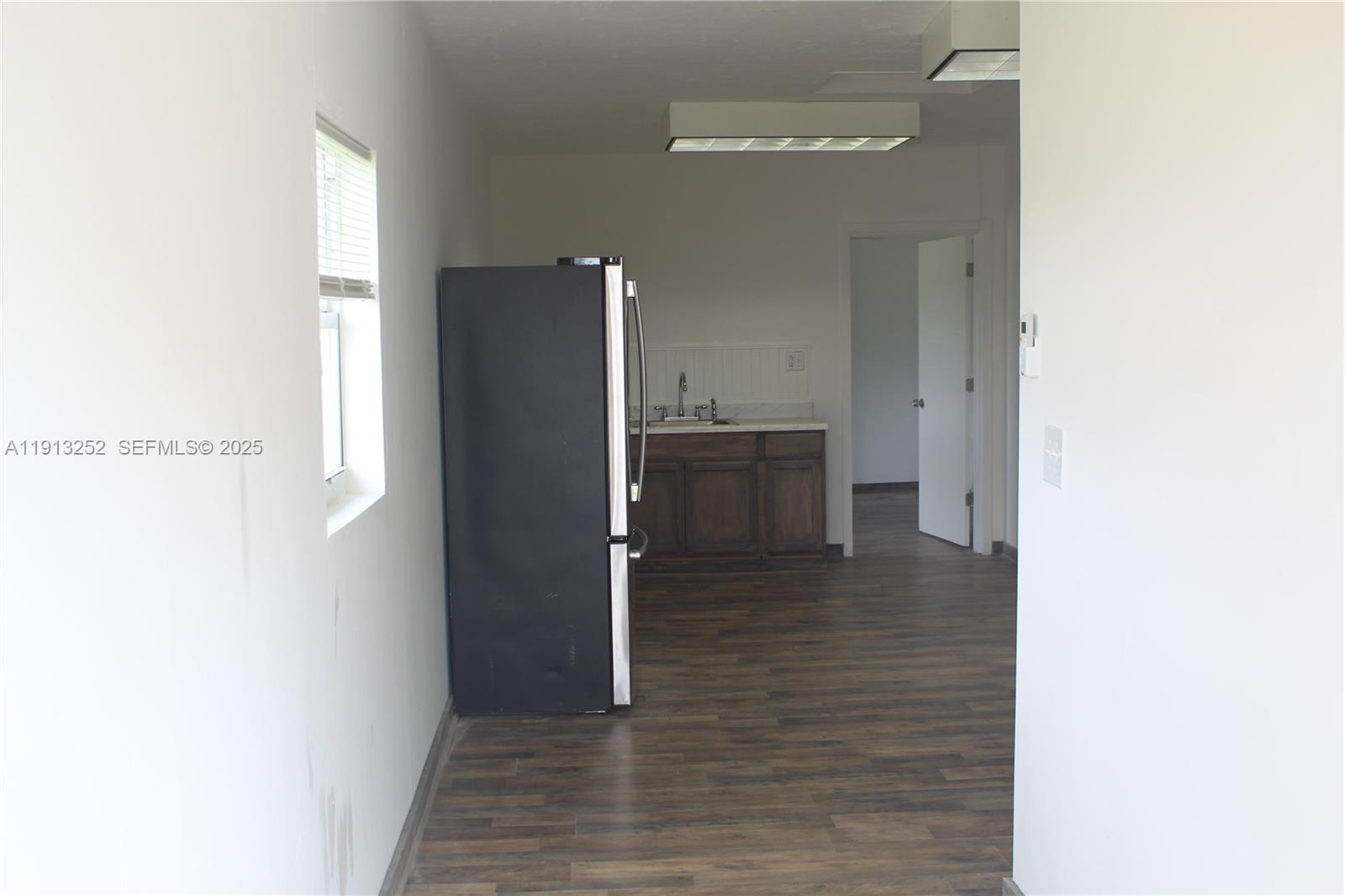 19879 Southwest 328th Street, Unit 2 Homestead, FL 33030 - Photo 17 of 20 a view of a refrigerator in kitchen and an empty room