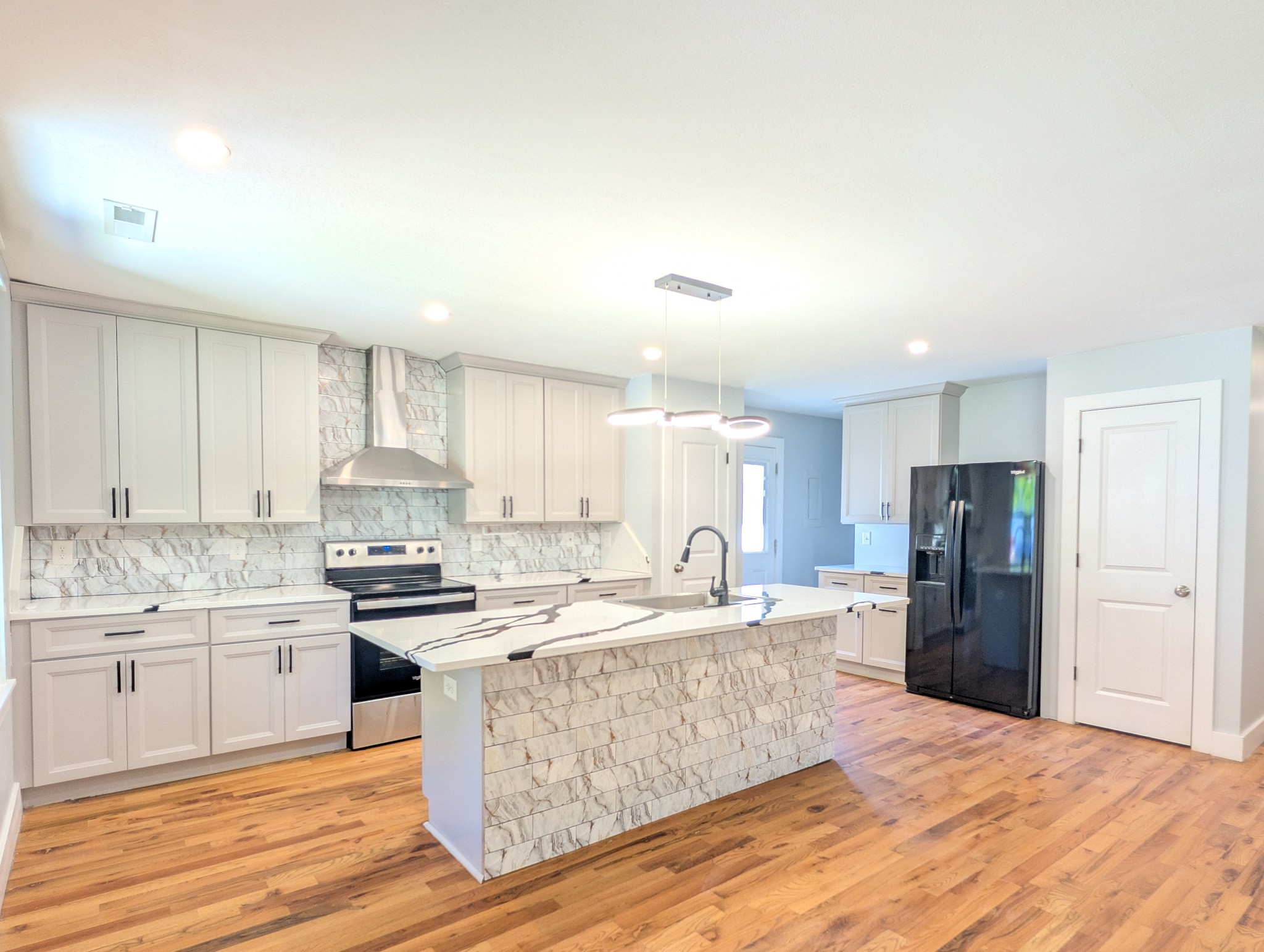 244 Warrior Road Madison, TN 37115 - Photo 7 of 24 a large kitchen with kitchen island a sink a stove a refrigerator and white cabinets
