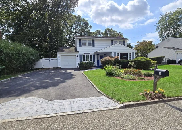 a front view of a house with a yard and a garage