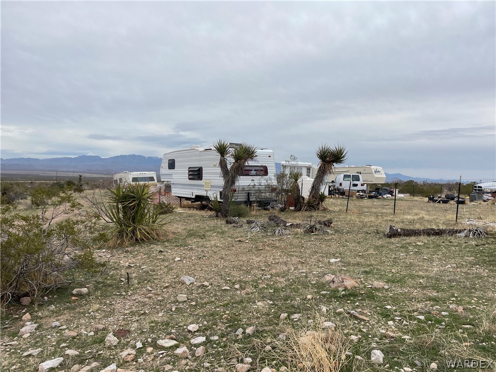 3096 South McCraken Road Golden Valley, AZ 86413 - Photo 2 of 8 a view of a dry yard with trees