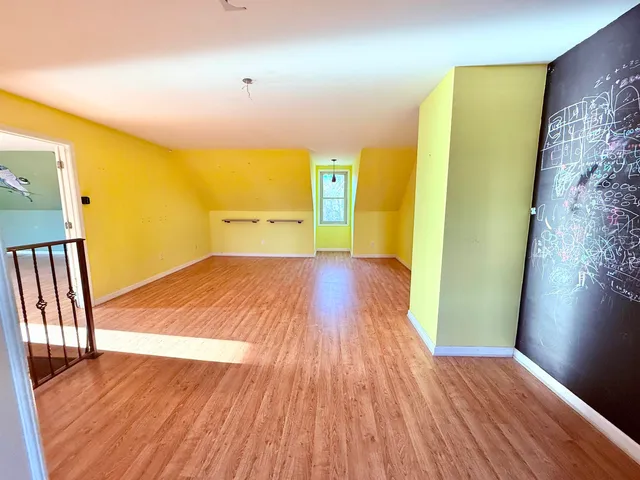 a view of a livingroom with wooden floor and a kitchen