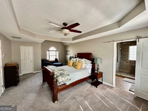 a bedroom with a bed and a mirror on the dresser