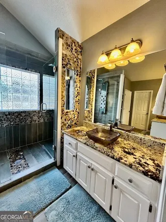 a bathroom with a granite countertop sink and a mirror