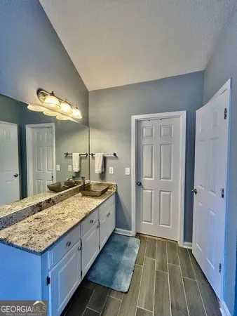 a bathroom with a granite countertop sink and a mirror