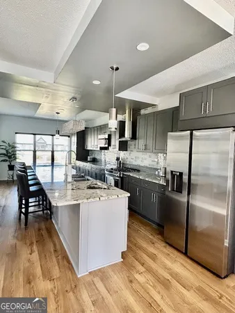 a kitchen with stainless steel appliances granite countertop a stove refrigerator and cabinets