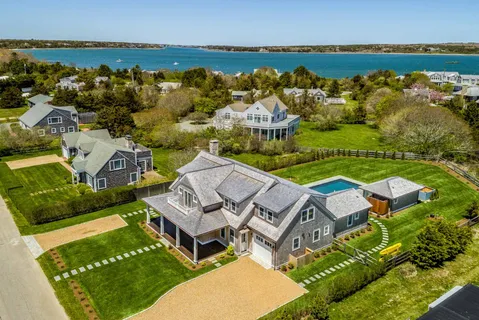 an aerial view of a house with a garden and lake view