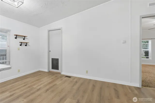 an empty room with windows and fan