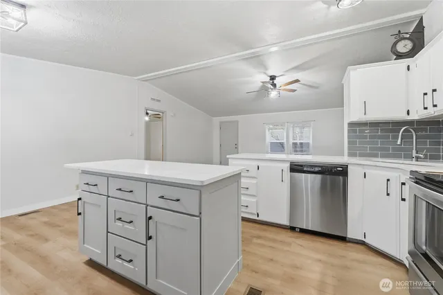 a kitchen with kitchen island a dining table and chairs