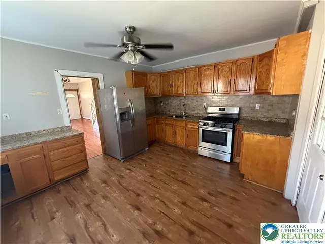 a kitchen with stainless steel appliances granite countertop a stove a sink dishwasher and a refrigerator