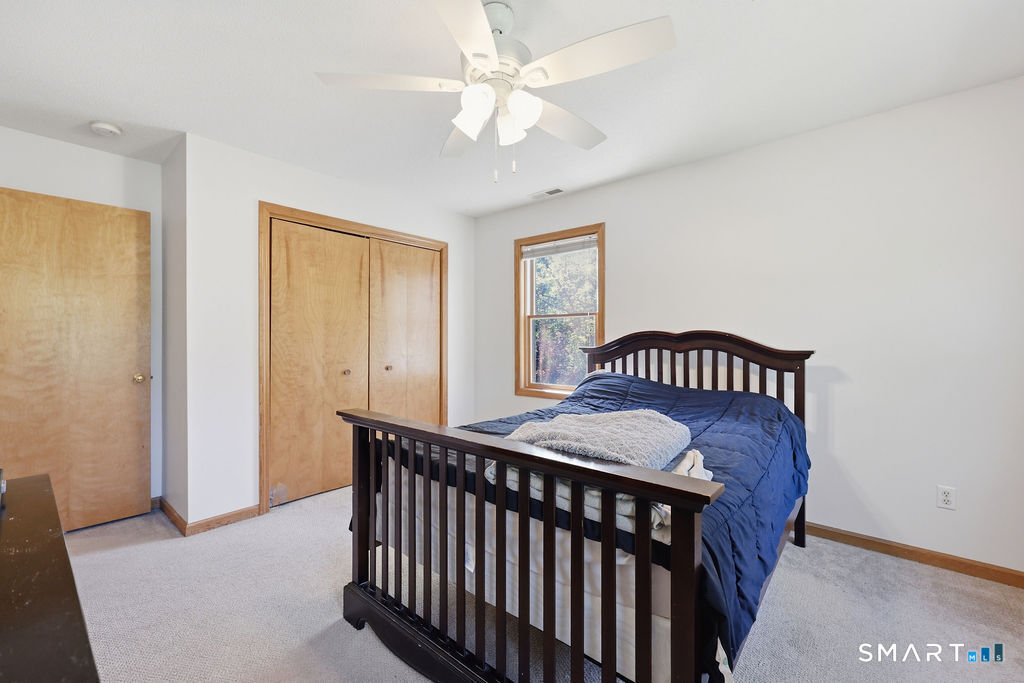 12 Forest Ridge Road Prospect, CT 06712 - Photo 21 of 40 a bedroom with a bed and a chandelier