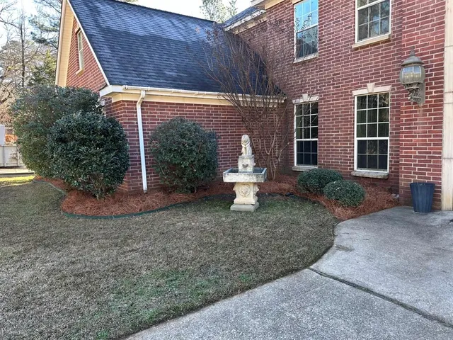 a view of a brick house with a yard