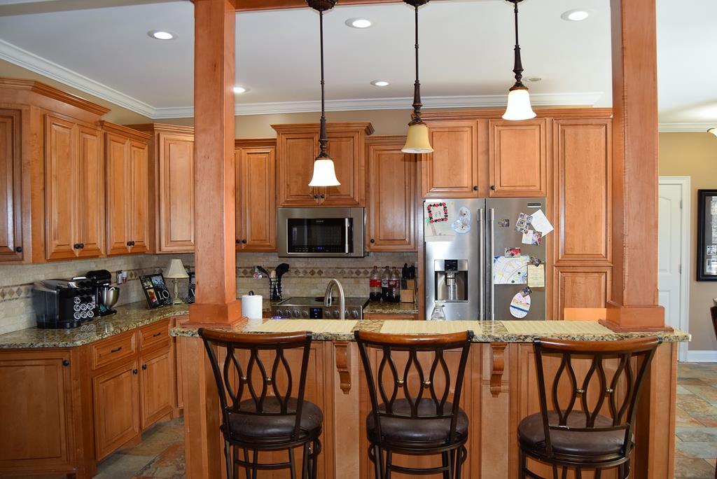 781 McKay Road Gray, GA 31032 - Photo 12 of 36 a kitchen with a dining table chairs cabinets and a sink