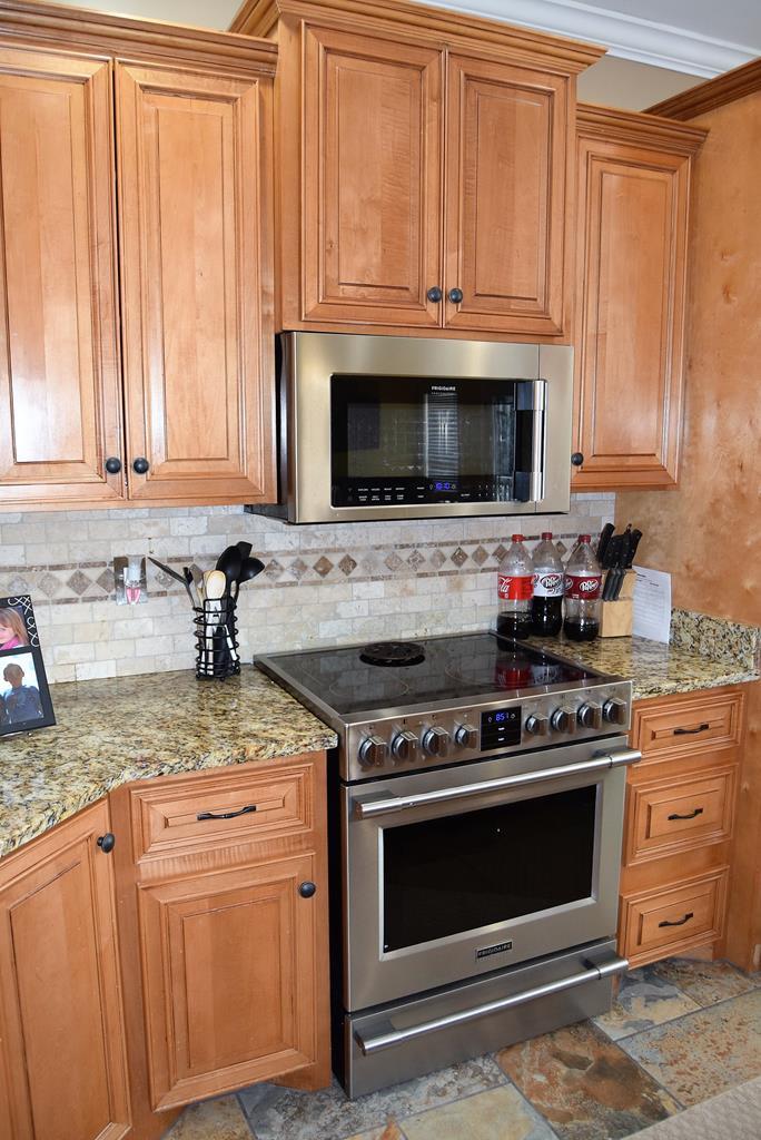 781 McKay Road Gray, GA 31032 - Photo 15 of 36 a kitchen with granite countertop a stove top oven microwave and cabinets