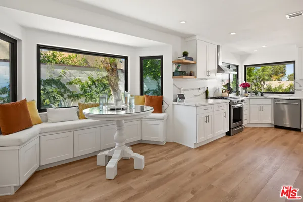 a kitchen with a sink wooden floor and white cabinets