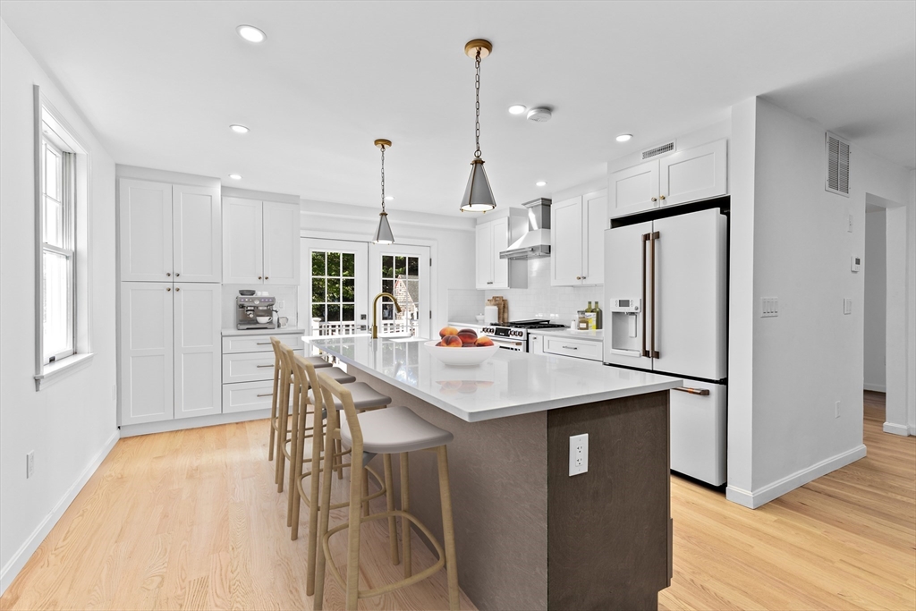 22 Clifford Court Hingham, MA 02043 - Photo 4 of 26 a kitchen with stainless steel appliances kitchen island a table chairs and a refrigerator