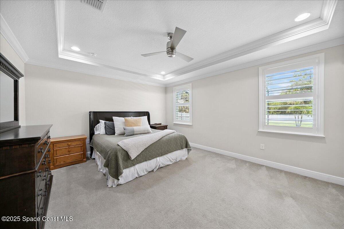4357 Preservation Circle Melbourne, FL 32934 - Photo 19 of 56 a bedroom with a bed rug dresser and a window