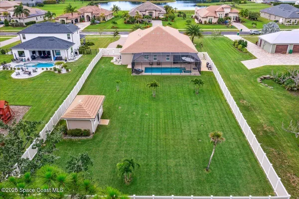 an aerial view of residential houses with outdoor space and trees