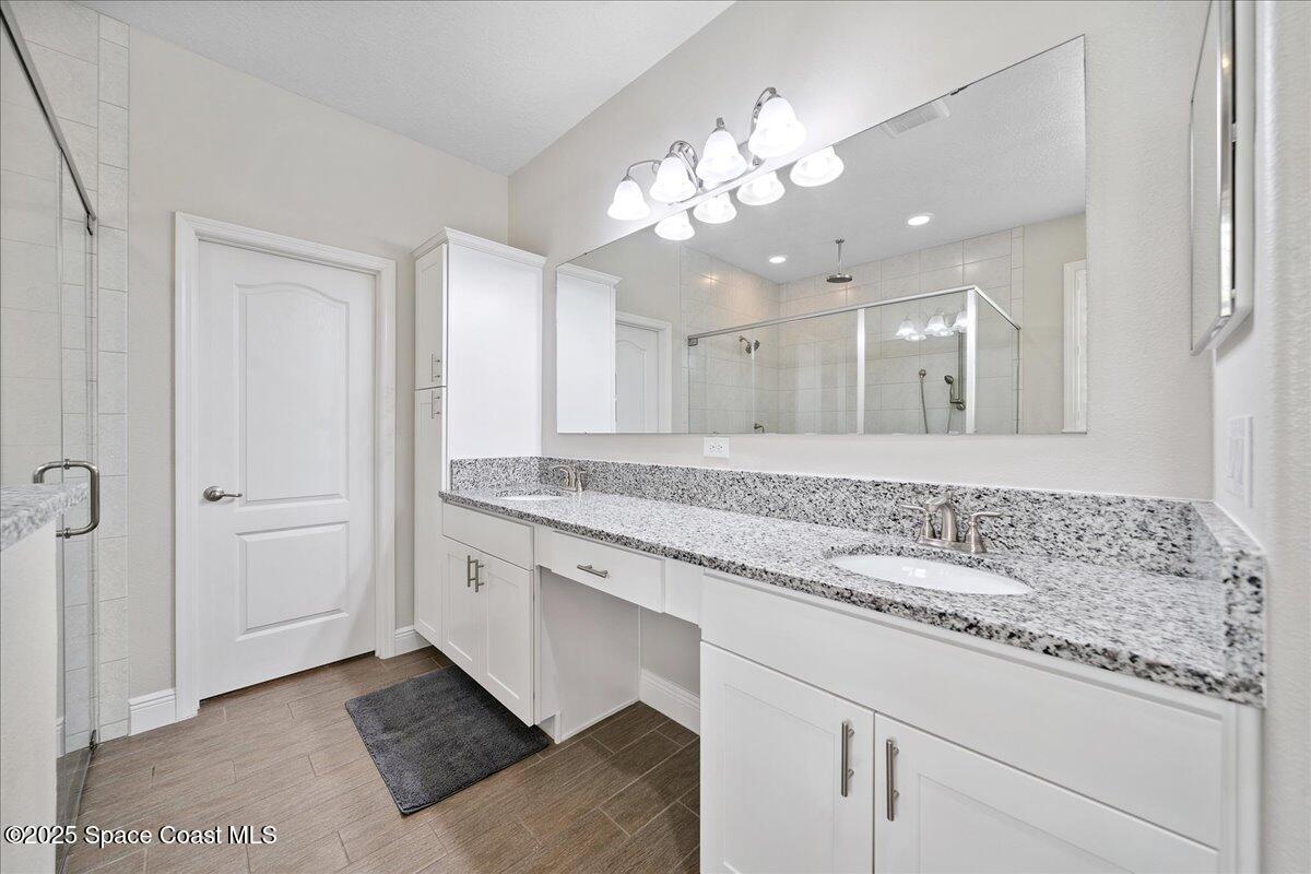 4357 Preservation Circle Melbourne, FL 32934 - Photo 22 of 56 a bathroom with a double vanity sink and a mirror