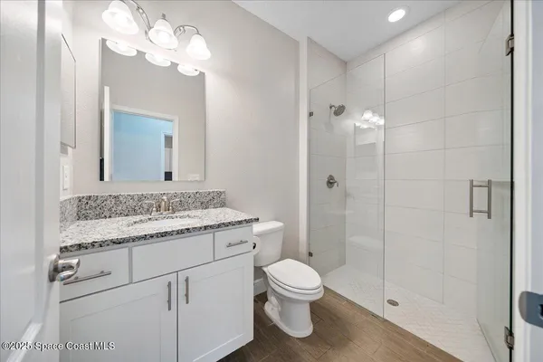 a bathroom with a granite countertop toilet sink and shower