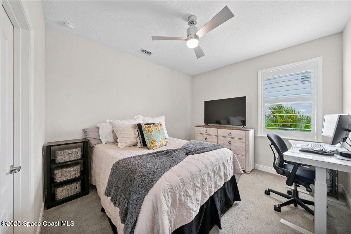 4357 Preservation Circle Melbourne, FL 32934 - Photo 30 of 56 a bedroom with a bed and a flat screen tv