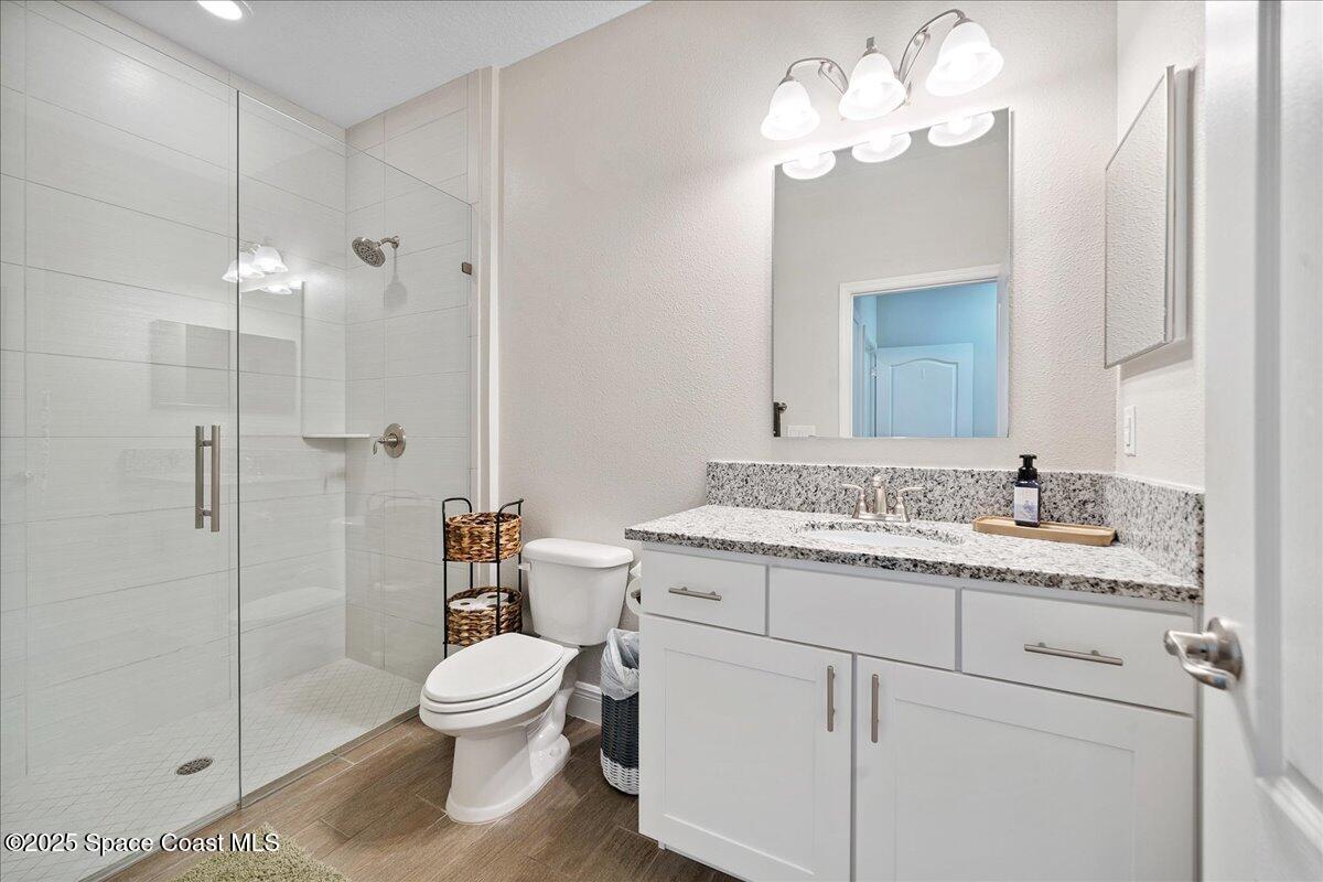 4357 Preservation Circle Melbourne, FL 32934 - Photo 32 of 56 a bathroom with a granite countertop toilet sink and shower