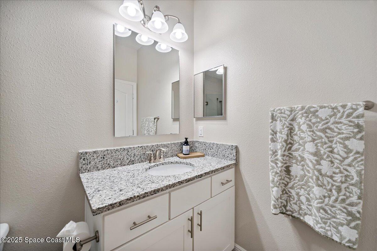 4357 Preservation Circle Melbourne, FL 32934 - Photo 34 of 56 a bathroom with a granite countertop sink and a mirror