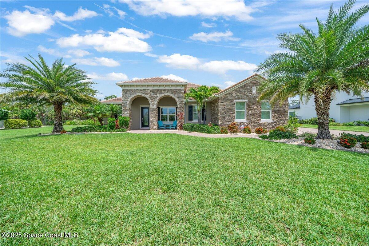 4357 Preservation Circle Melbourne, FL 32934 - Photo 46 of 56 a front view of a house with garden and trees