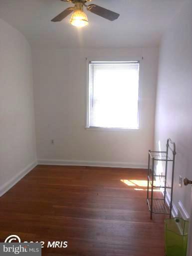 1615 Ramblewood Road Baltimore, MD 21239 - Photo 12 of 19 a view of empty room with wooden floor and fan