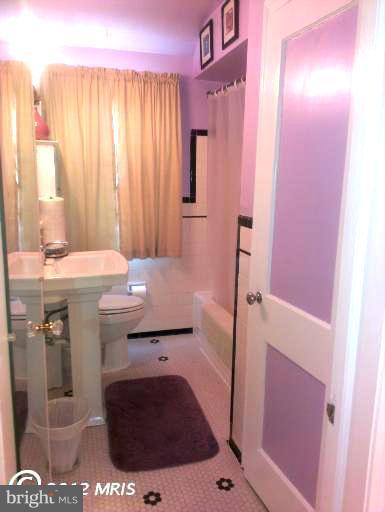 1615 Ramblewood Road Baltimore, MD 21239 - Photo 13 of 19 a bathroom with a sink a toilet and shower