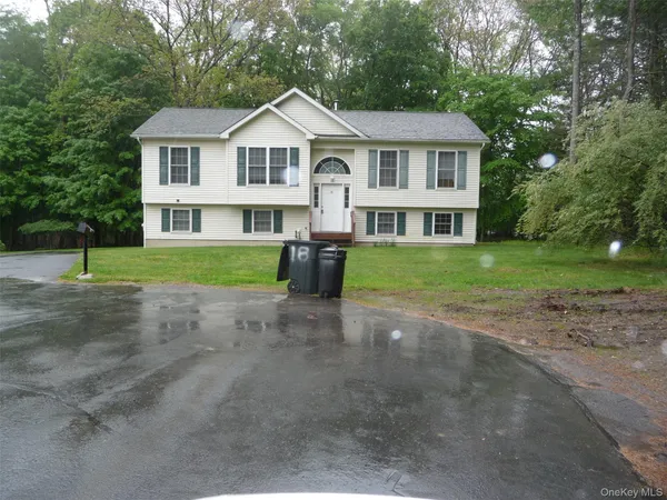 a front view of a house with a yard and trees