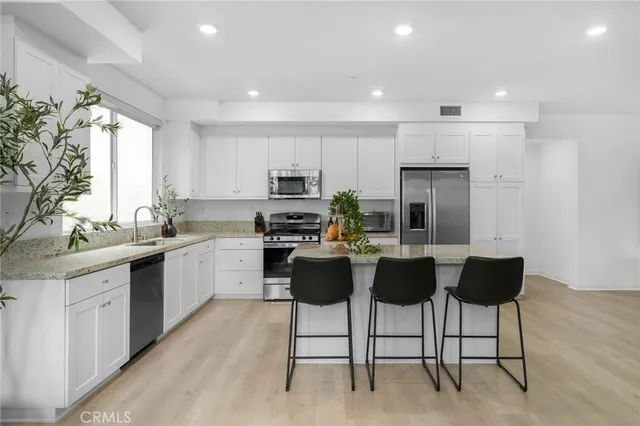 a kitchen with stainless steel appliances granite countertop a sink stove and microwave