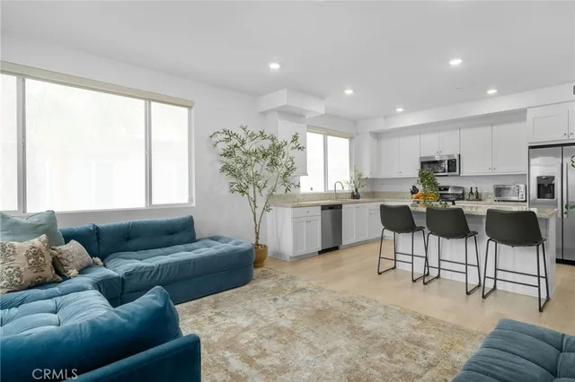 a kitchen with granite countertop white cabinets white appliances and a window